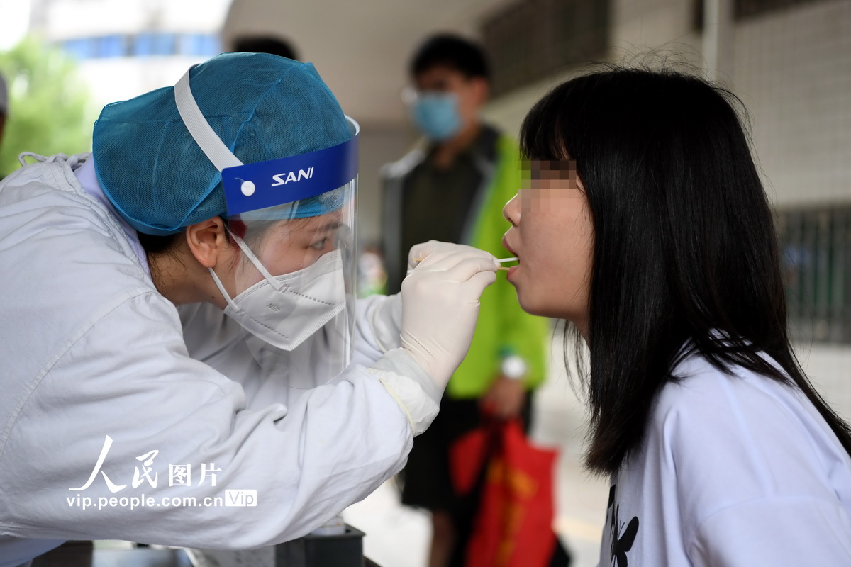 5月7日,南昌大学第一附属医院护士正在为企业员工进行核酸咽拭子采集.