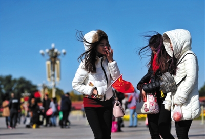 10月31日,天安门广场,游客们大多穿着羽绒服在风中游玩