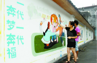 大学生志愿者正在绘制文化墙