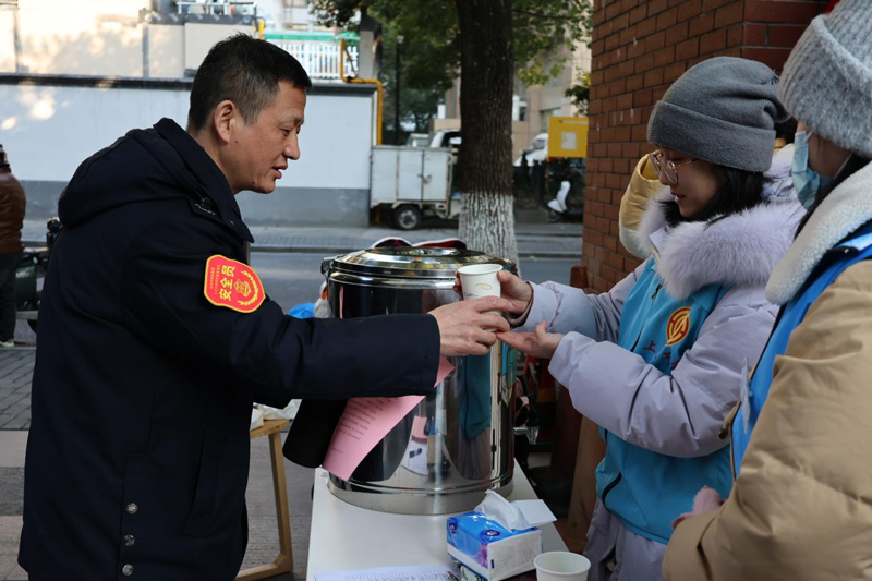 志愿者为户外劳动者送上姜茶。湖滨街道供图